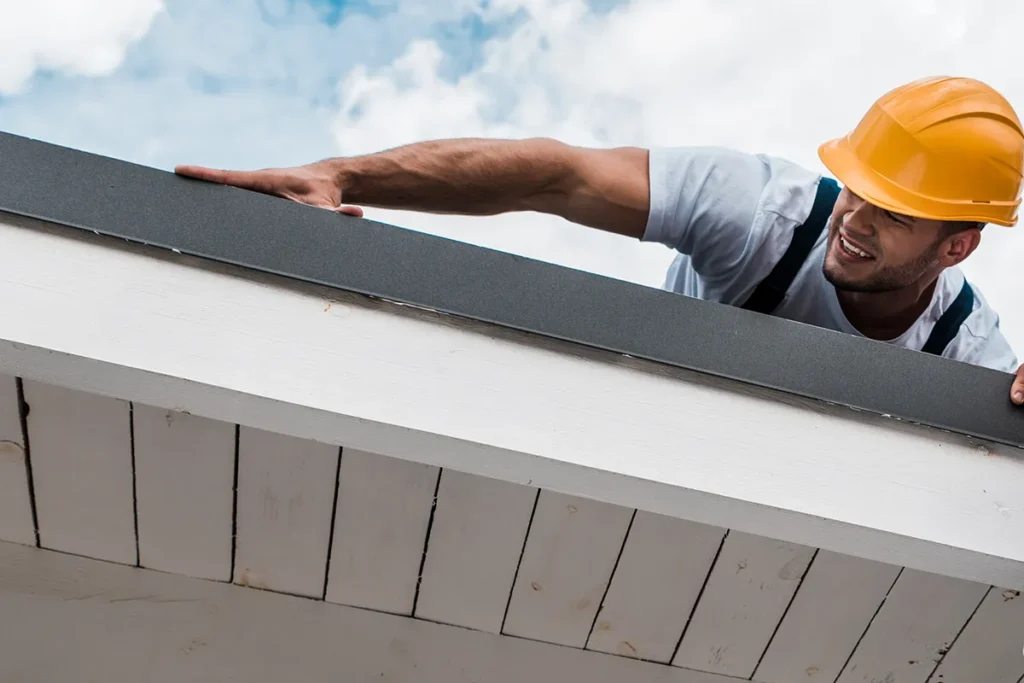 low-angle-view-of-handsome-handyman doing roof inspection.